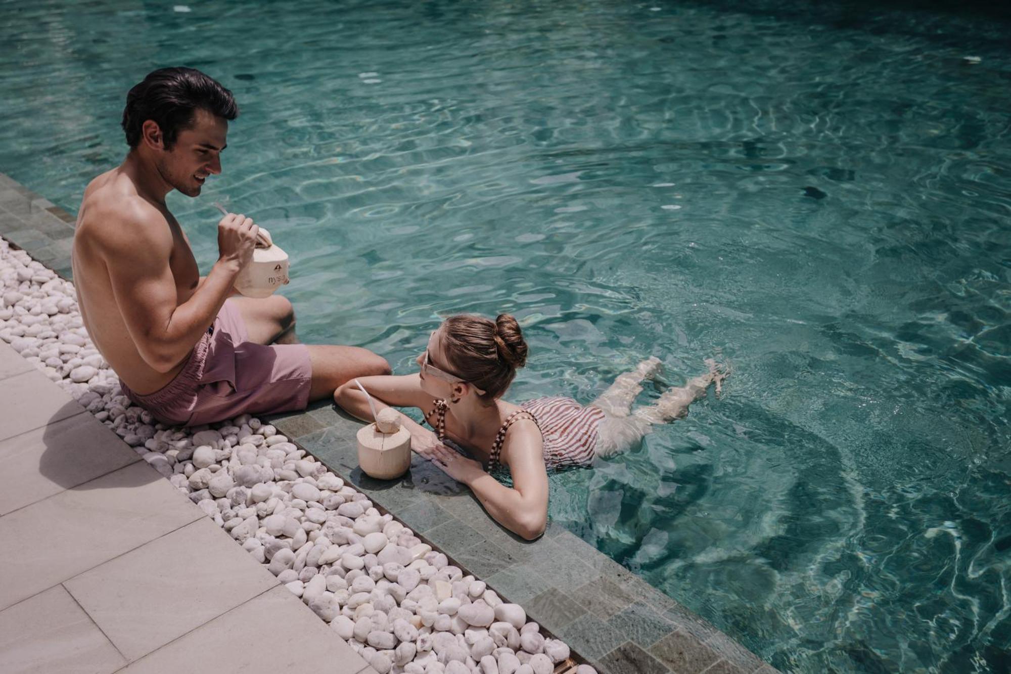 Nysa Hotel Bangkok Sukhumvit 11 Exterior photo A couple drinking coconut water in a swimming pool